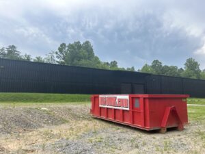 red 837 Junk Dumpster Rental at a Warehouse