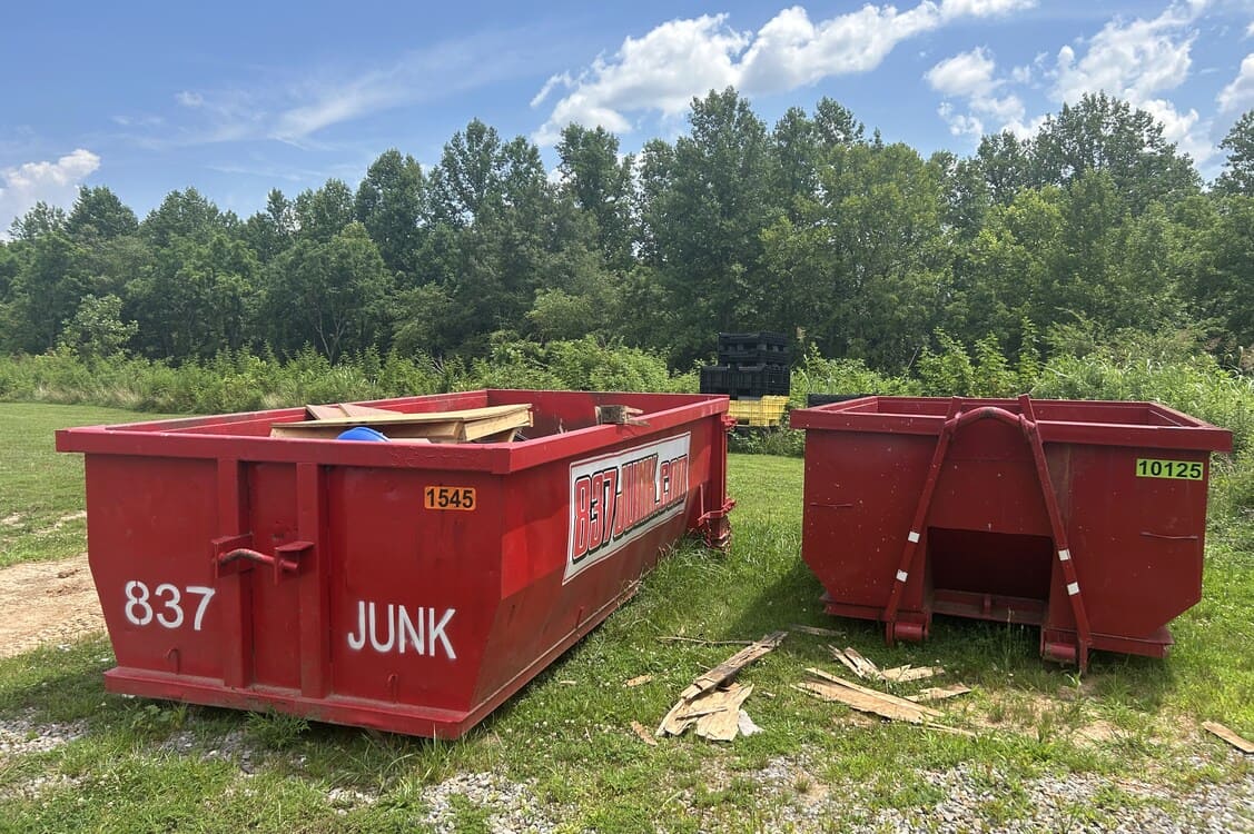 Two green 837 JUNK containers placed near a service area