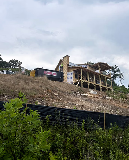 roll off dumpster rental on the side of a mountain supporting a new home construction site holding all the trash and building material waste
